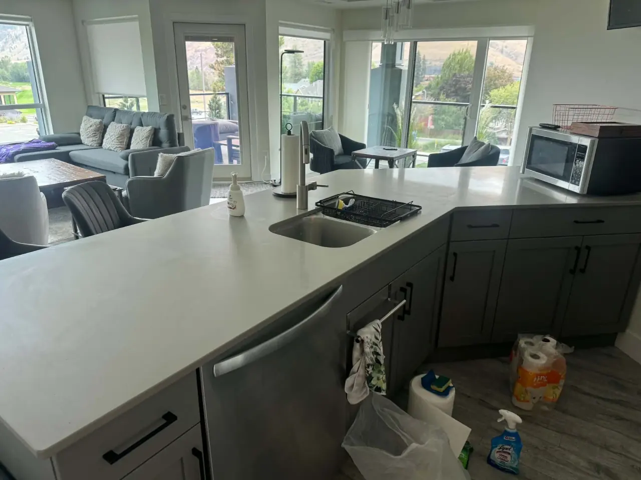 Open-plan kitchen counter and living area in a Kamloops condo during a cleaning visit